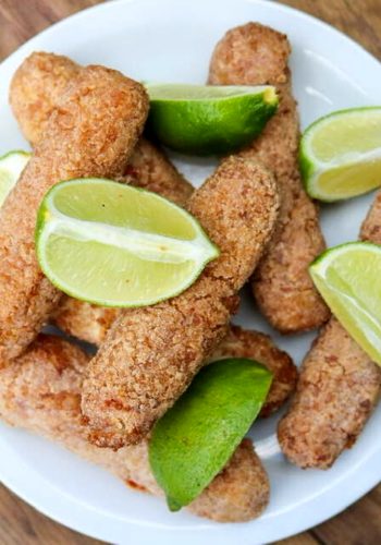 A plate full of vegan ham croquetas with lime wedges